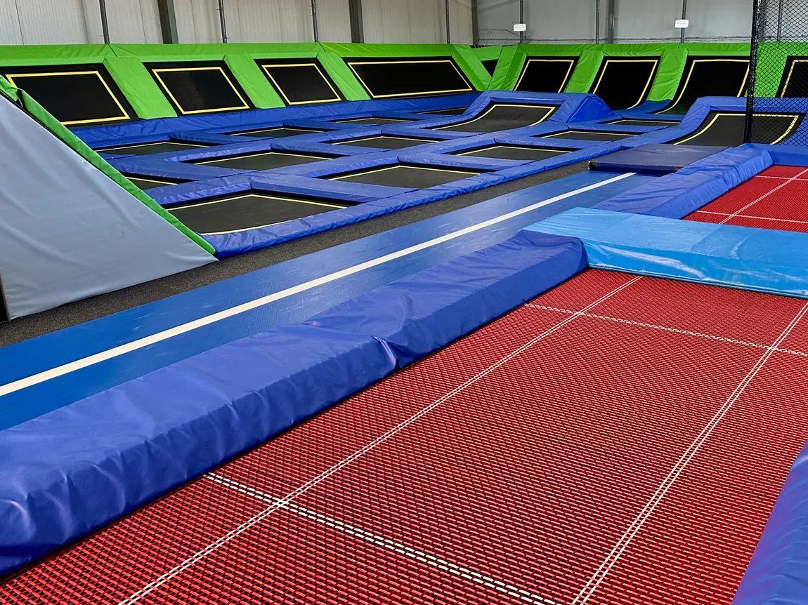 Trampoliny sportowe z czerwonym kortem w hali Jumpout
