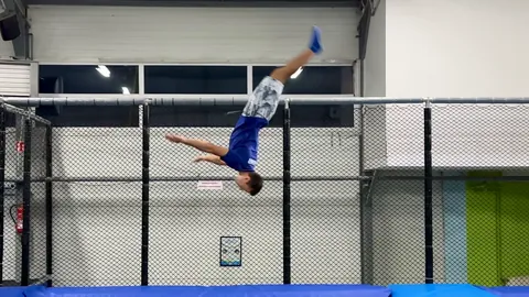 Chłopiec robi salto nad airtrackiem w Jumpout